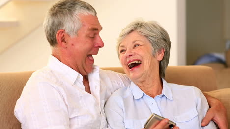 Senior-couple-sitting-on-couch-taking-a-selfie