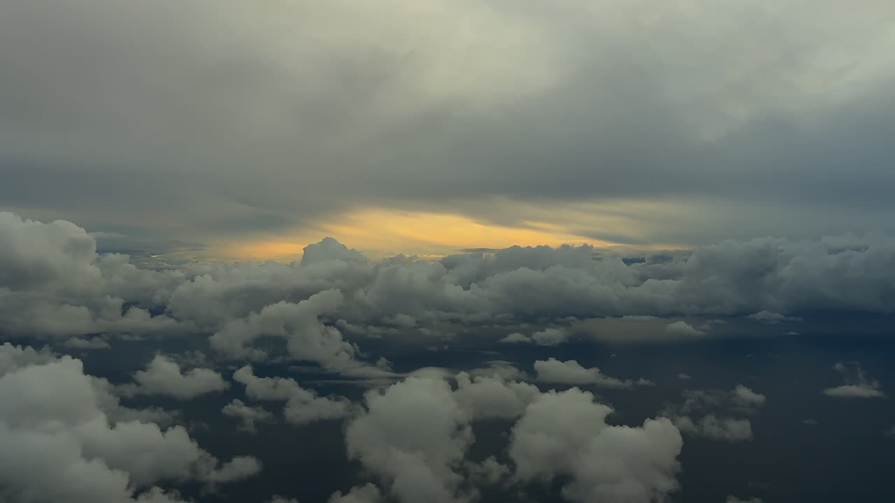 An immersive pilot’s perspective from the cockpit of a jet flying through a stormy cloudscape over the Mediterranean Sea surroended by storm clouds, with the sunrise light ahead, over Palma island