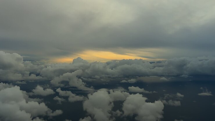 An immersive pilot’s perspective from the cockpit of a jet flying through a stormy cloudscape over the Mediterranean Sea surroended by storm clouds, with the sunrise light ahead, over Palma island