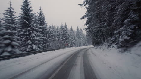 driving carefully on curvy road with heavy snow fall