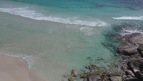 Aerial-top-down-of-female-person-swimming-crystal-clear-water-of-Pacific-Ocean-during-bright-sunny-day