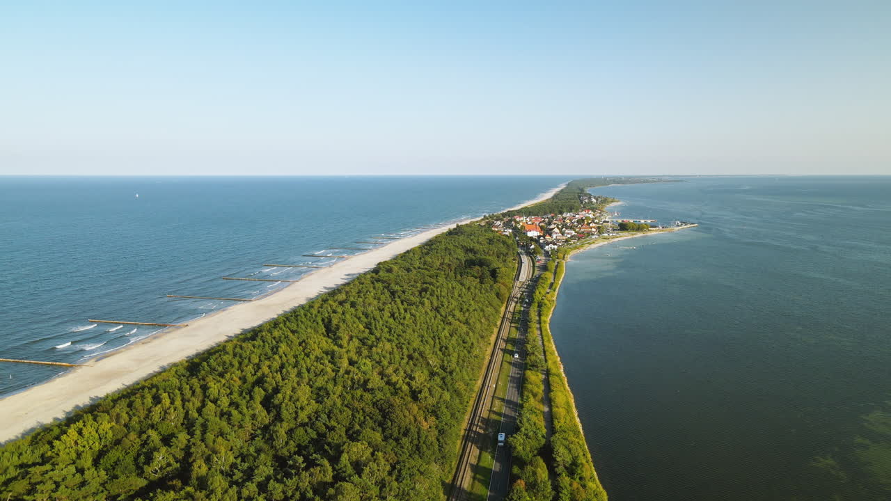 Luftfoto i slowmotion af en lige vej langs bugten og havet, klar himmel og filmisk udsigt over Kuznica i Polen