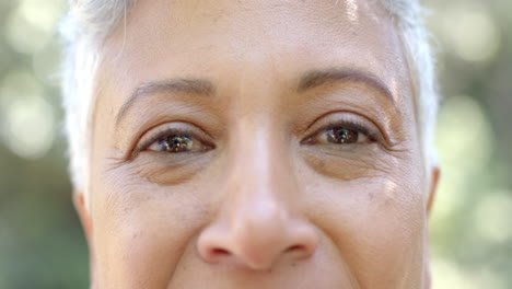 portrait of happy senior biracial woman with short hair in sunny garden at home, slow motion