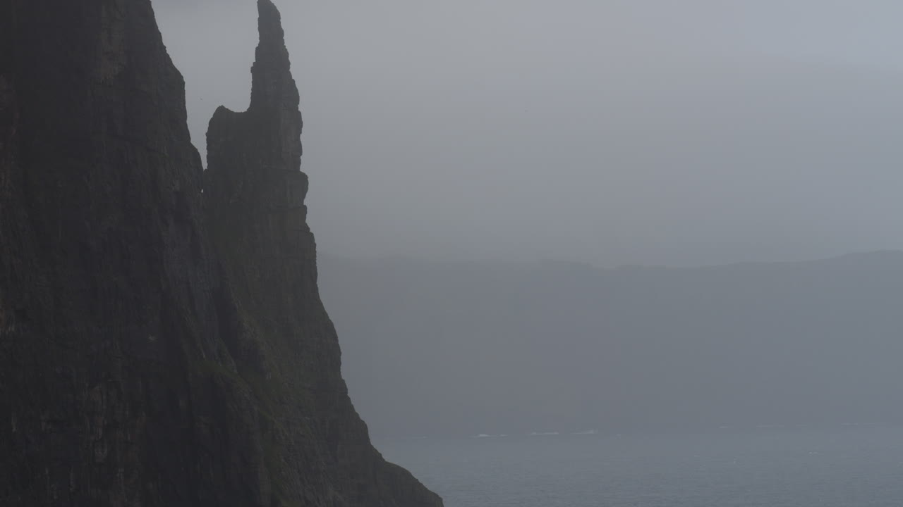 Trollkonufingur: Foggy cliff landscape in the Faroe Islands