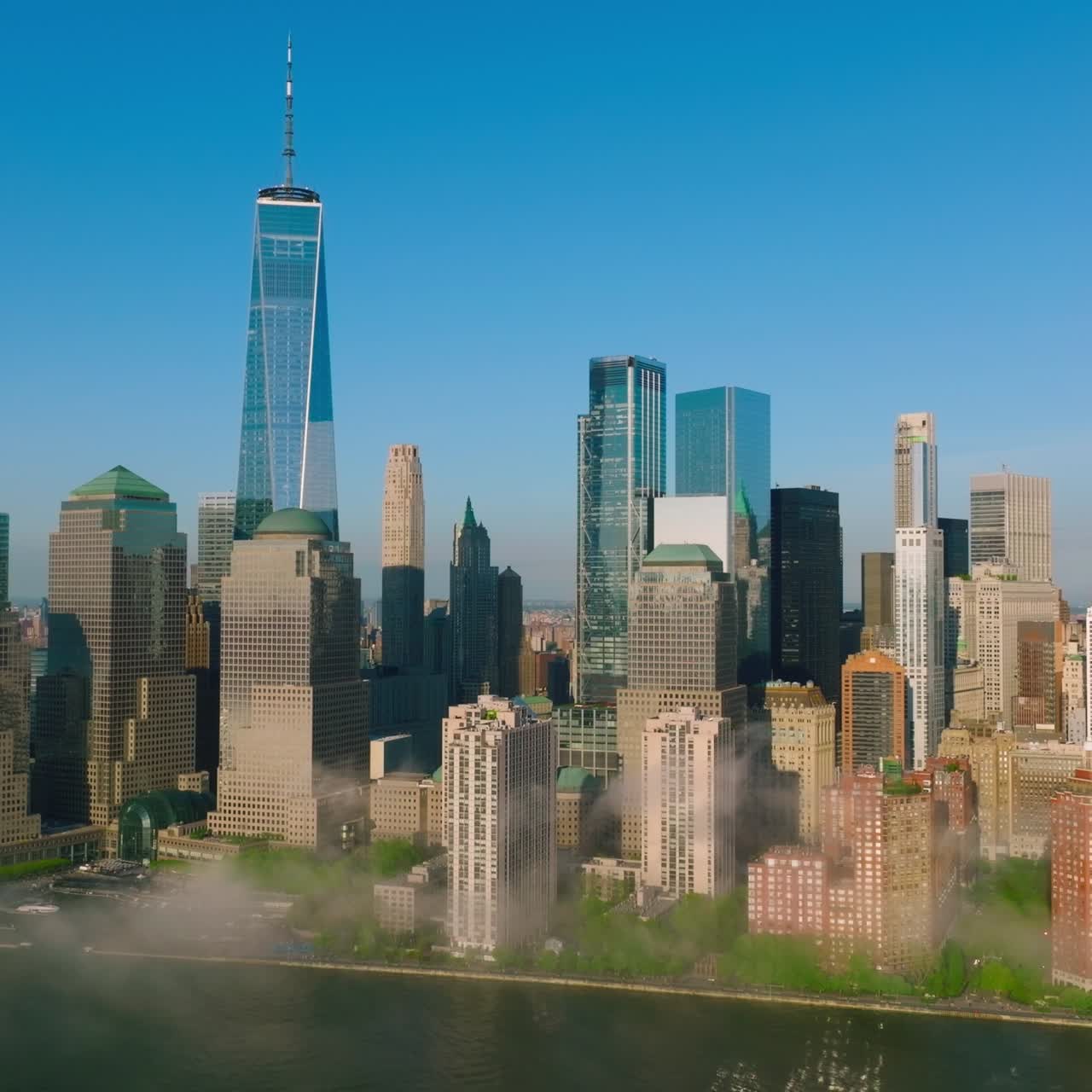 Outstanding New York skyscrapers at the backdrop of blue clear sky. White smoke coming up from the East river
