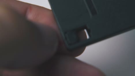 young man shows hole in floppy disc on white background