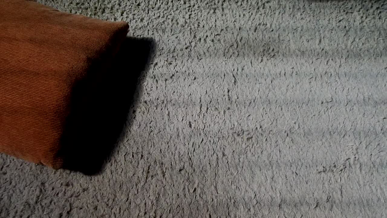 pequeño cojín cuadrado en la alfombra beige, comenzando a disparar de izquierda a derecha