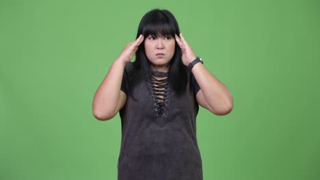 Beautiful overweight Asian woman having headache