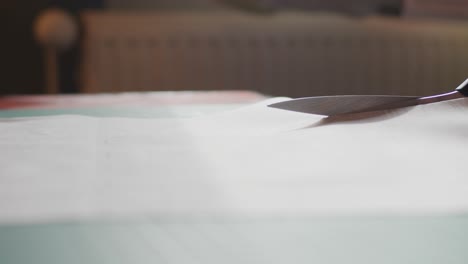 Scissors-cutting-through-fabric-on-a-table-slowly