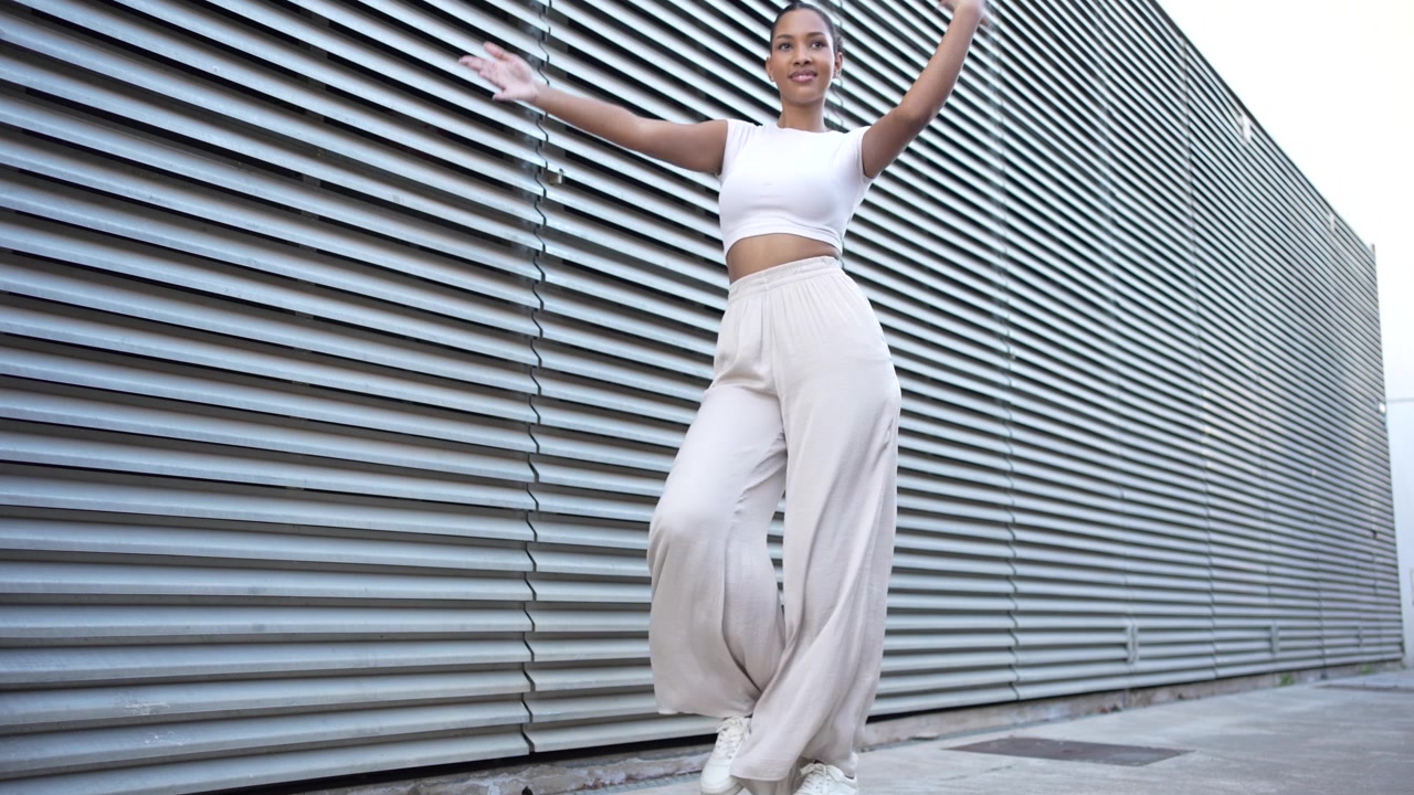 A stylish woman is walking against a modern background filled with architectural design