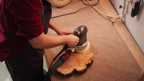 woodworking specialist uses angle grinder on wood, close up shot