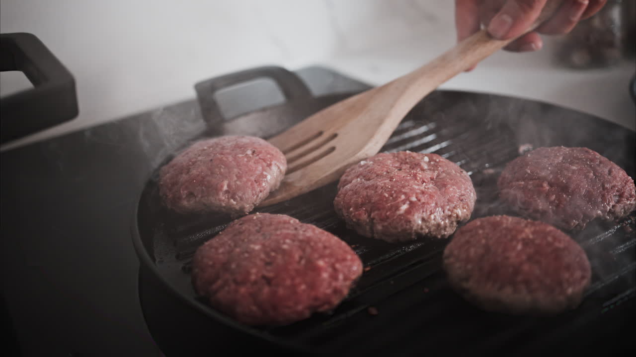 Burger patties being cooked on a grill pan