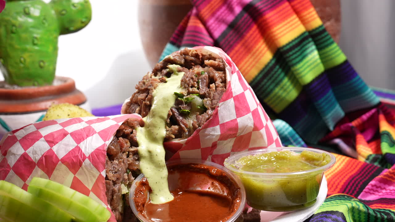 Versare salsa guacamole su un burrito di carne asada - serie food truck.