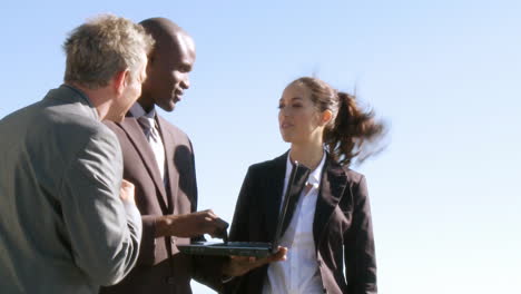 Three-businesspeople-having-a-meeting-outdoors