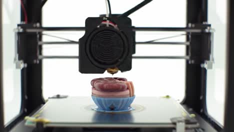 a high-precision 3d printer meticulously creates a detailed model in a colorful bowl, showcasing the innovation and creativity of modern manufacturing technology.