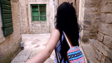 The girl leads the guy through the old streets