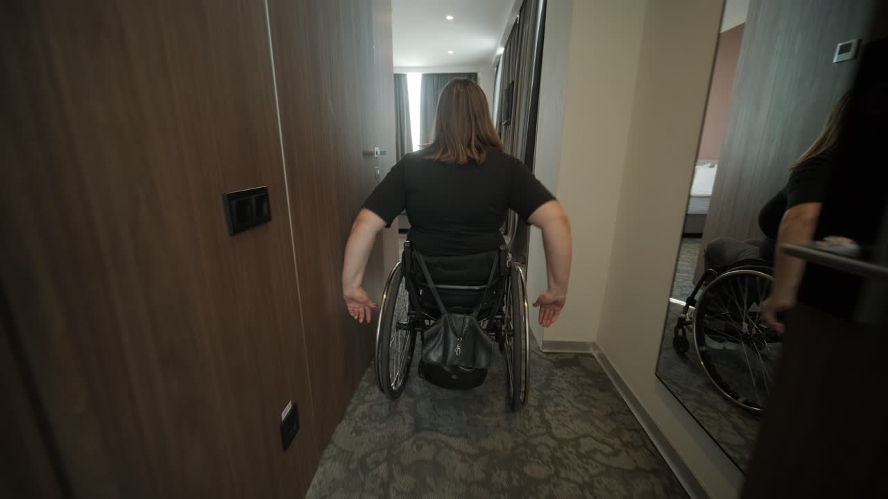 una mujer en silla de ruedas navega a través de una habitación de hotel, destacando alojamientos accesibles y diseño inclusivo. la imagen hace hincapié en la movilidad, la independencia y la infraestructura de hospitalidad moderna.