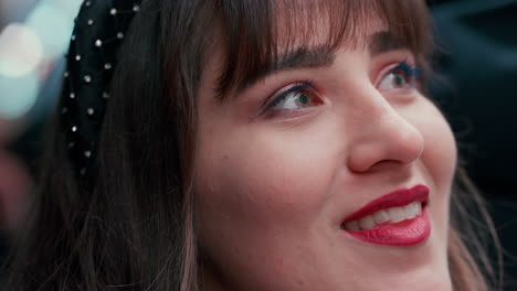 primer plano de una hermosa mujer con cabello oscuro sonriendo y mirando asombrado por encima durante una noche en cámara lenta