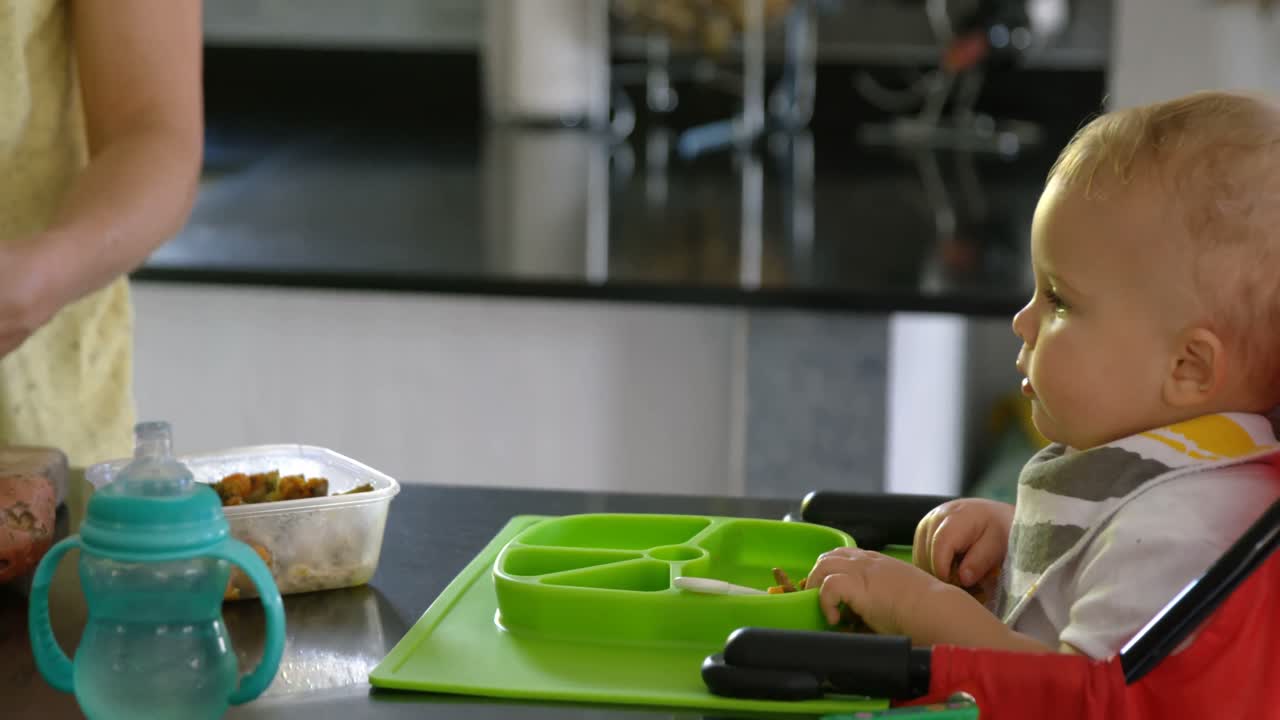 Madre che prepara la colazione per il suo bambino in cucina 4k