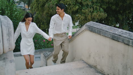 Emotional-pair-running-stairs-city.-Excited-macho-man-swirling-embracing-woman