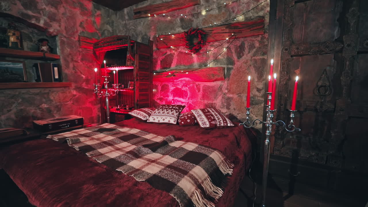 Cozy room with Christmas decorations. Christmas decorated bedroom with many lights, candles and red light. Room with garlands