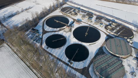 aerial overview of sewage water treatment plant basins in winter