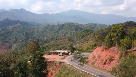 two persons riding motorcycle on beautiful rural road, northern thailand