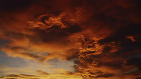 timelapse of a sea of clouds during sunset going from bright orange to darkness