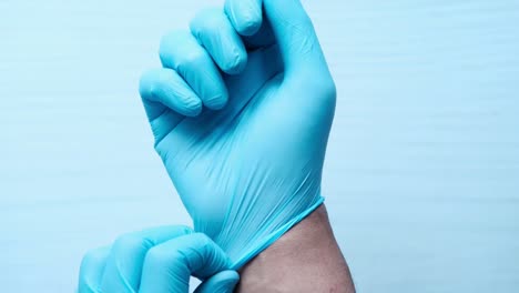 putting on blue medical gloves