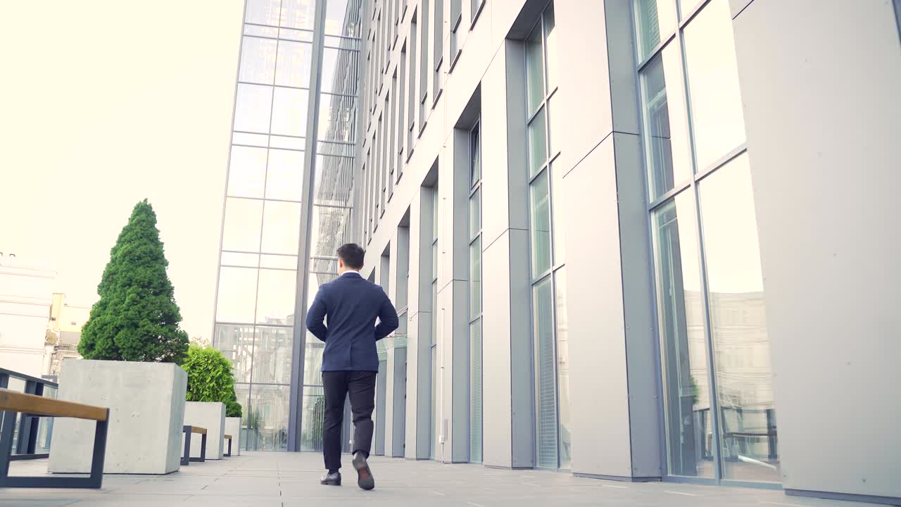 rear view of asian businessman go fast on uban background of modern office work in downtown.