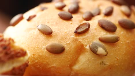 close up of a bun with sesame and pumpkin seeds