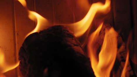 close up shot burning flame at fireplace on wooden logs