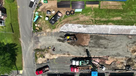 drone top down static excavator scoop and spin to remove dirt from construction site