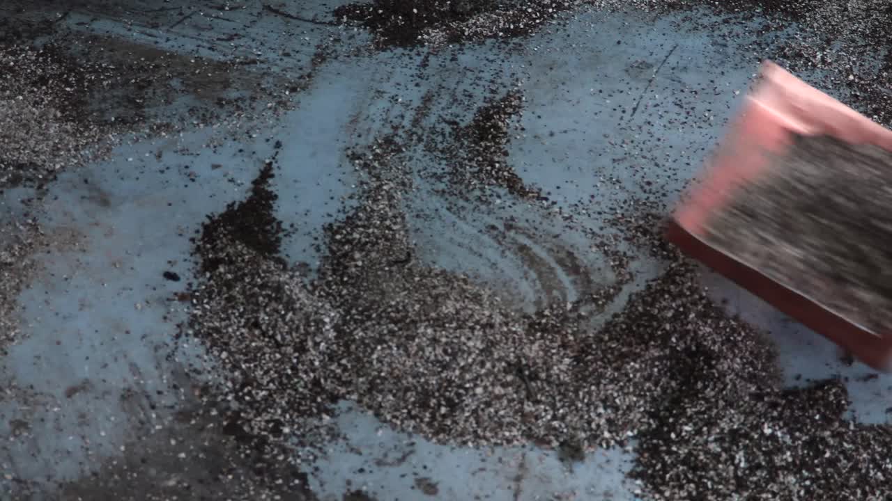 가게를 청소하기 위해 수제 스쿠퍼를 사용하는 나무 그늘 정비사