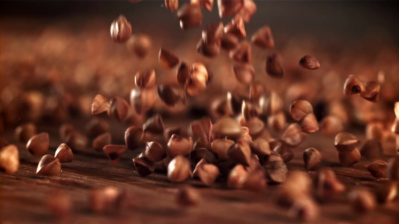 Grano saraceno crudo che cade su uno sfondo rustico in legno