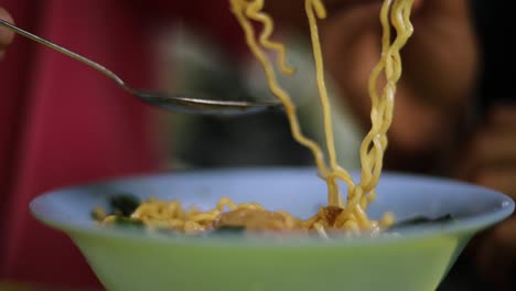 Shot-of-someone-eating-their-dinner-and-playing-with-their-noodles