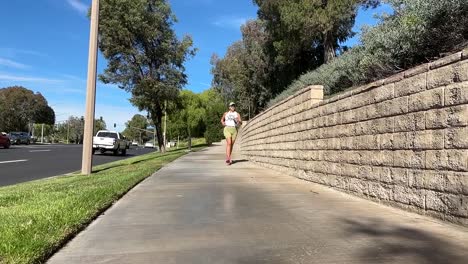 hispanic woman running on sidewalk on sunny day