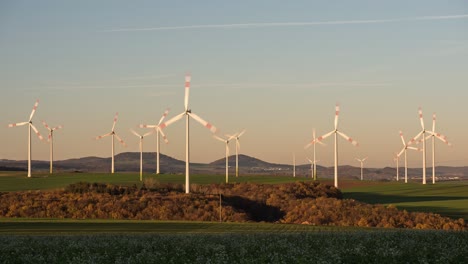 wind farm - wind turbines spinning and generating electricity at golden hour in dungenheim, eifel, germany