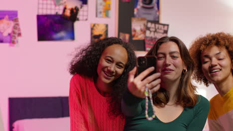 three friends taking a selfie in a bedroom