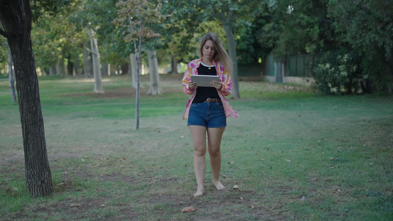mujer usando una tableta en un parque