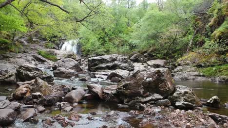 Kinematisches-Herauszoomen-Einer-Drohnenaufnahme-Des-Wasserfallflusses-Im-Schottischen-Hochland