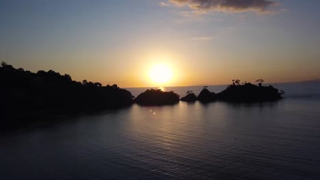 stunning aerial 4k footage of tropical sunset. beautiful lens flares, dark sky, and jungle.