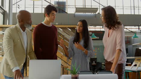 ejecutivos discutiendo sobre la computadora portátil en la oficina 4k