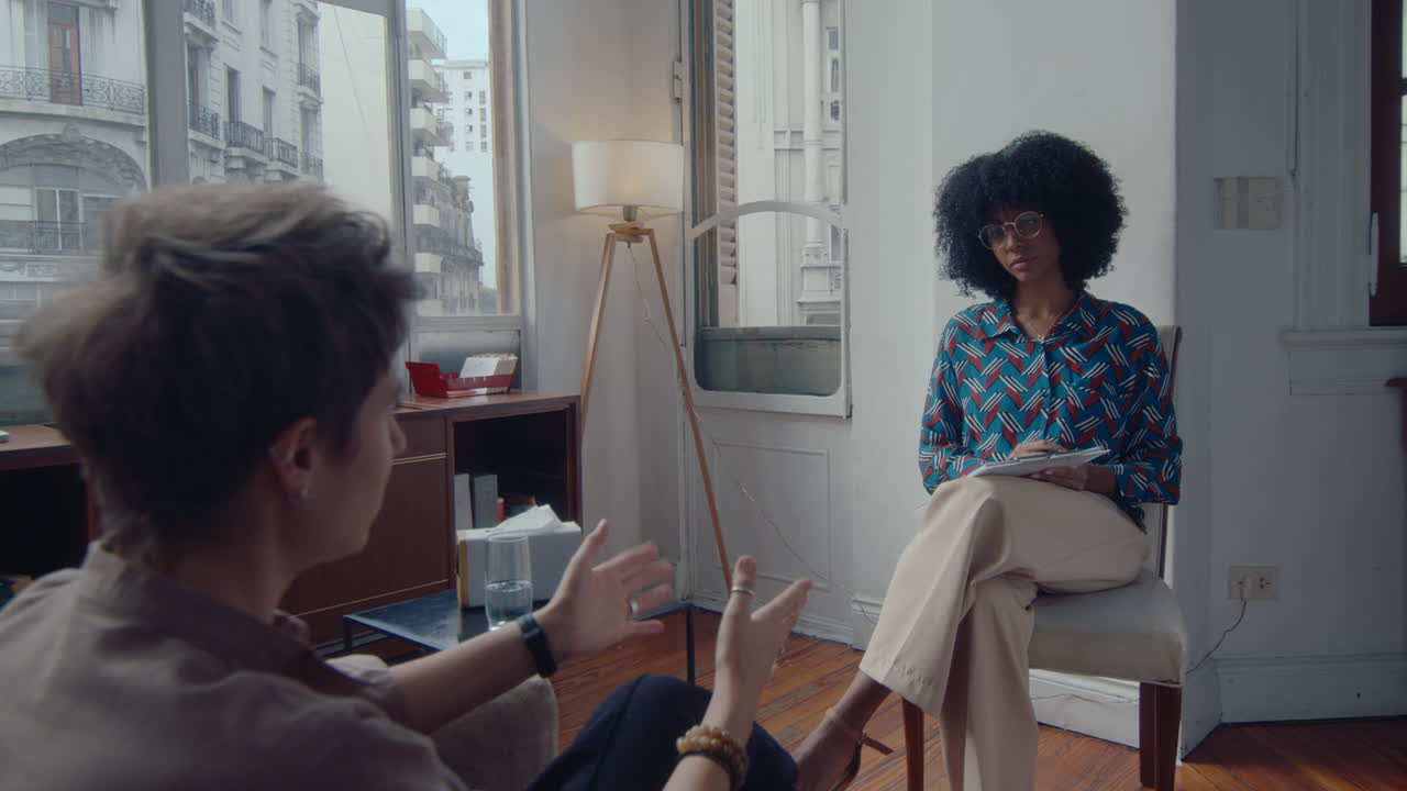 Young Black Female Therapist Talking with Woman on Counseling Session