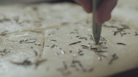 chef making pattern on focaccia dough