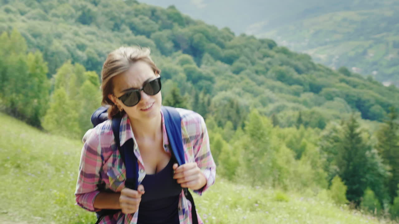 una turista muy cansada con una mochila sube el camino de la montaña fuerza de voluntad y resistencia física