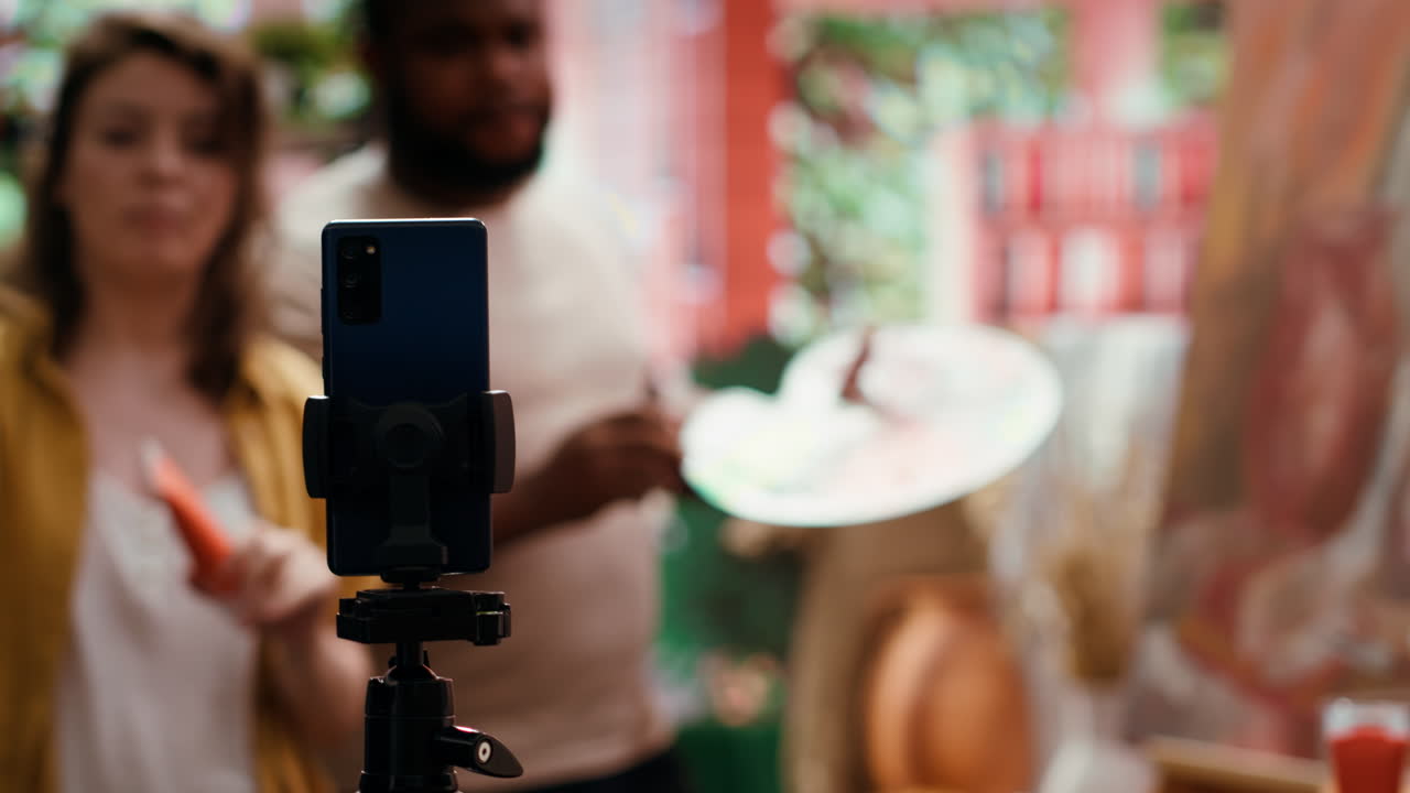A couple are painting and recording a video