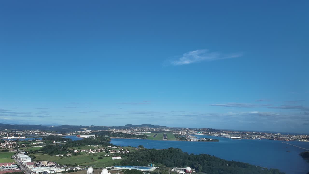 An immersive pilot’s eye FPV aerial view taken from a jet cocklpit in a real time approach to Santander airport runway, overflying the bay, in a quiet sunny summer morning, unclouded sky
