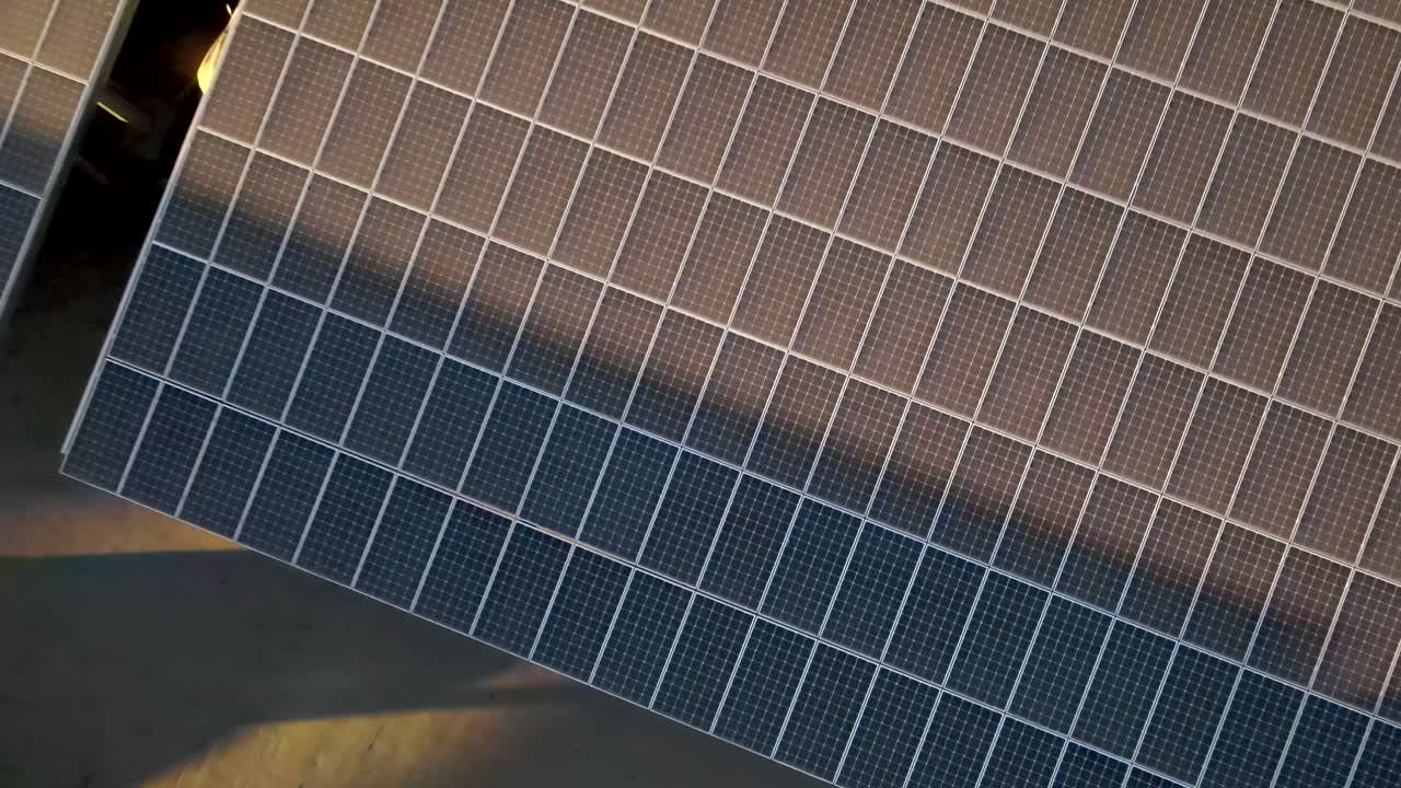 Vista dall'alto di pannelli solari per energia rinnovabile in ascesa, con ripresa aerea in allontanamento