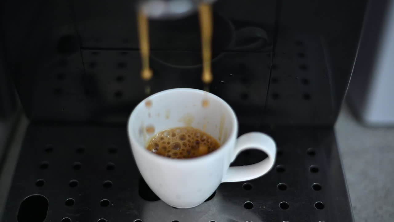 Macchina da caffè che prepara un espresso in una tazza bianca in cucina